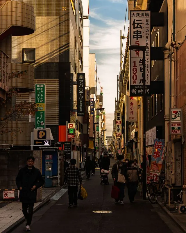signs stack up the buildings while the street stays in shadow