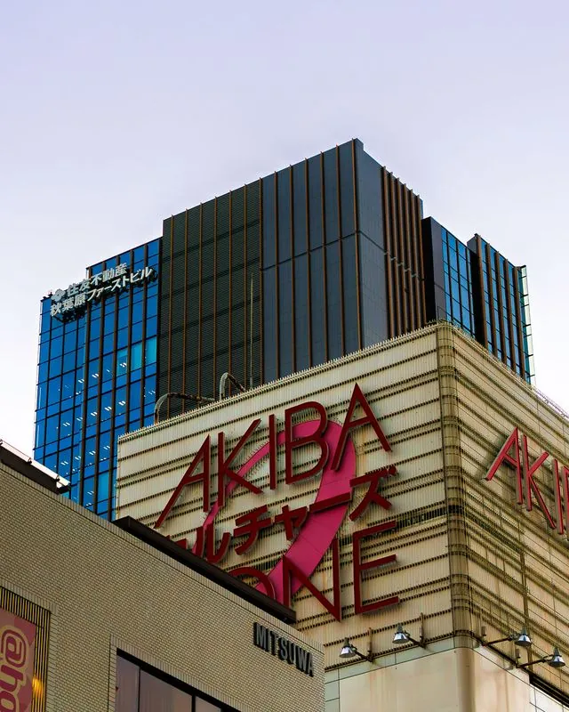 a pink ribbon loops over the red signage in akihabara